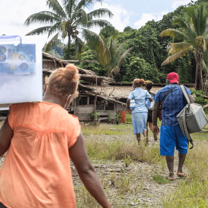 Nurse Rose and her team walk through small settlements during their two-hour journey to bring COVID-19 vaccines to Kuvamiti village.