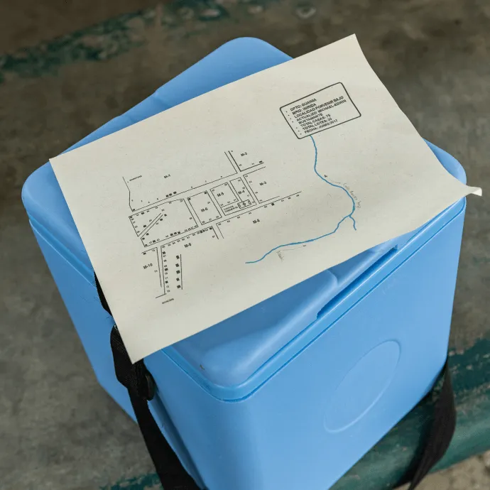 A map of the Porvenir neighborhood sits on top of an insulated box where COVID-19 vaccines are stored in Pajuil, Colombia during a door-to-door vaccination effort