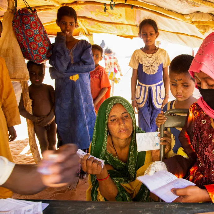 Health worker Adizatou checks information on a vaccination certificate during a COVID-19 vaccination campaign at a displacement camp in Ménaka.