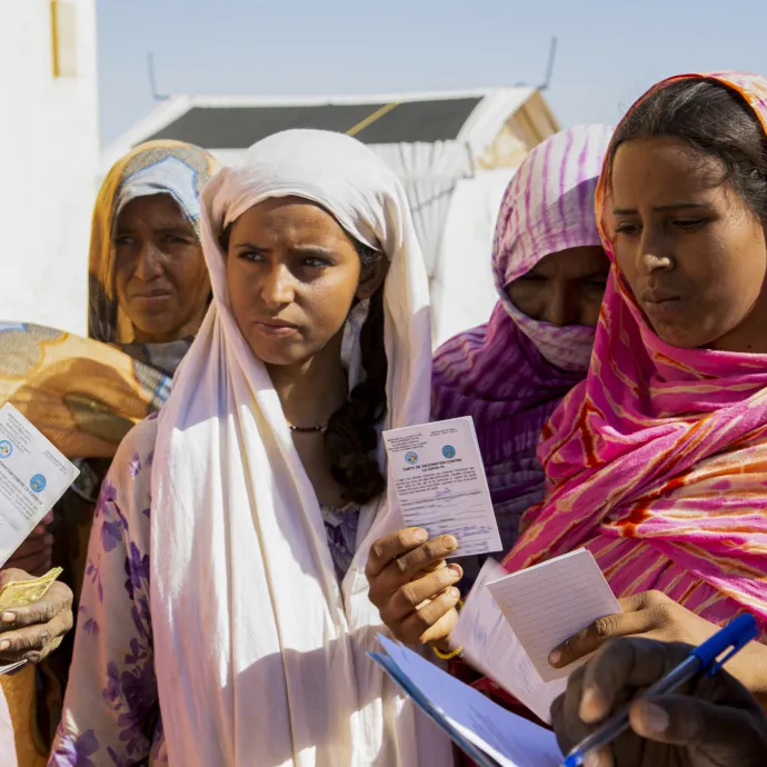 Women receive their COVID-19 vaccination certificates at a displacement camp.